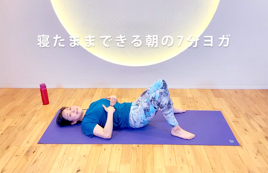 仰向けになってポーズを解説するこた先生