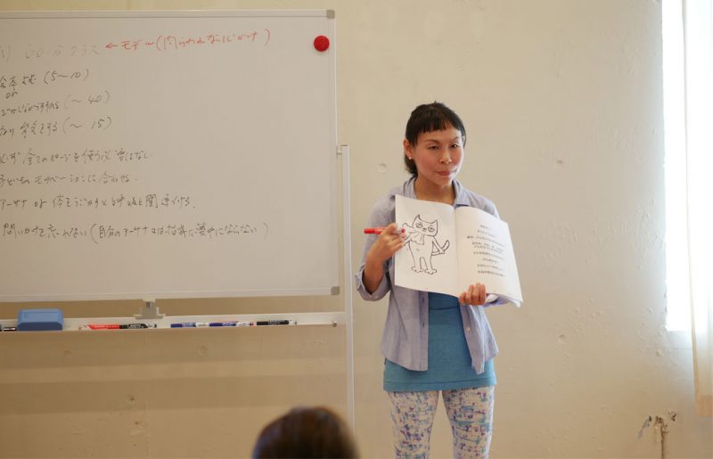 片岡まり子先生のキッズヨガワークショップ風景。絵本を持って説明する片岡先生
