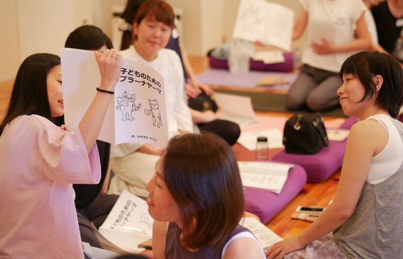 片岡まり子先生のキッズヨガワークショップ風景。生徒が読み聞かせのワークをしている様子
