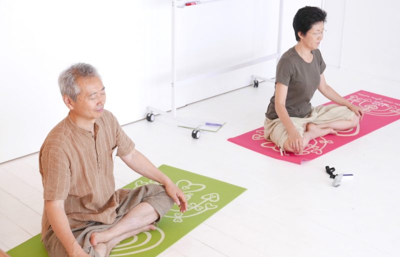目をつむってあぐらをしている野口夫妻