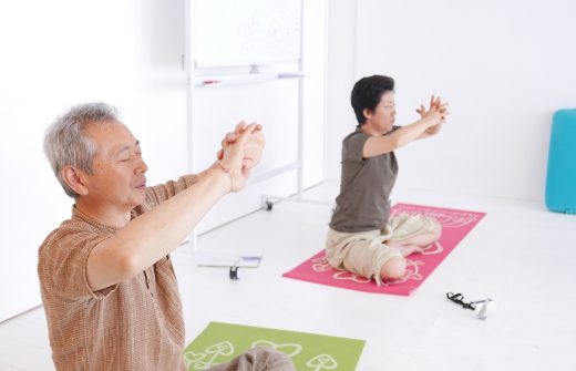 目をつむってヨガクラスをしている野口夫妻