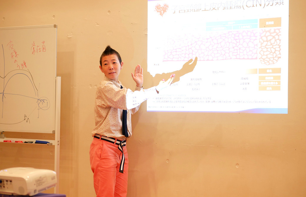 高尾美穂先生が投影された表を指さして説明している様子