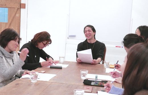 和也先生がテキストを持ちながら笑顔で話をしている