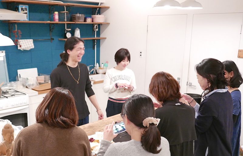 笑顔でキッチンにいる和也先生を囲んでいる生徒さんたちの後ろ姿