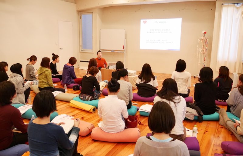 壁の前で話をする高尾先生と壁に向かって座っている生徒さん
