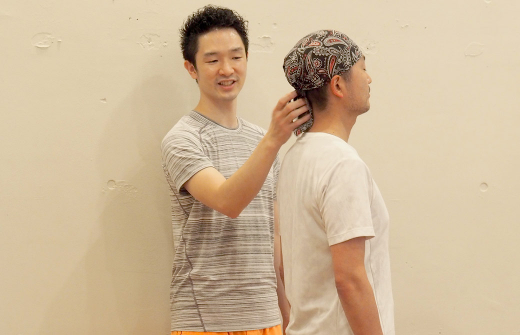 大江清一朗先生が生徒さんの背骨をタッピングしている様子