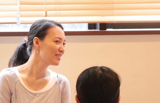 真理先生が笑顔で生徒さんの話を聞いている横顔