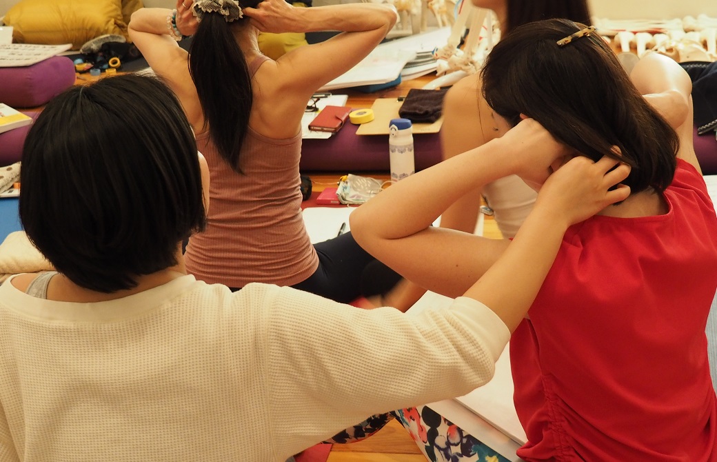 頸椎1番を触る女性
