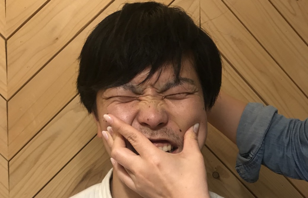 顴髎のツボを押される男性