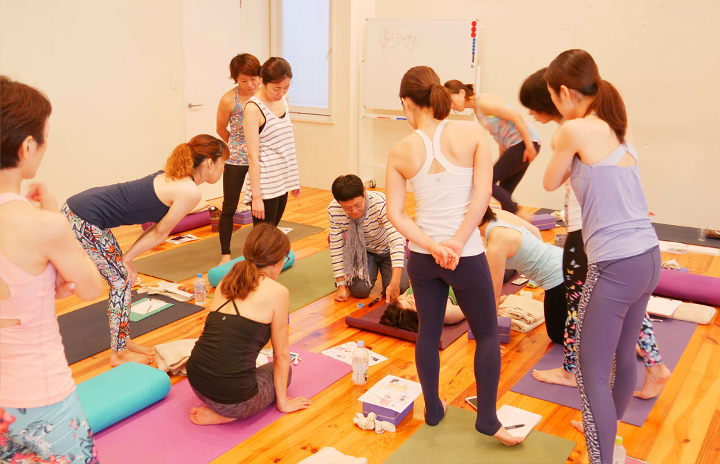 内田かつのり先生がマットに横になっている生徒さんをモデルにして説明している様子
