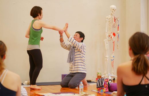 内田かつのり先生が生徒さんと手と手を合わせて、手首の力の入れ方を説明している様子