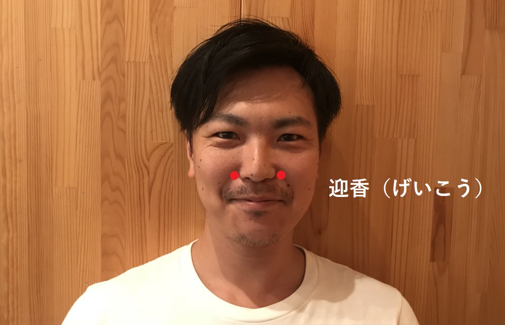 迎香のツボのポントをはった男性
