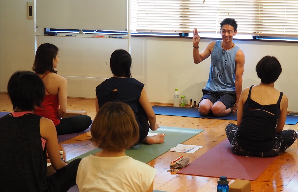 ヨガ講師浅野佑介先生が生徒さん達の前に座って話をしている