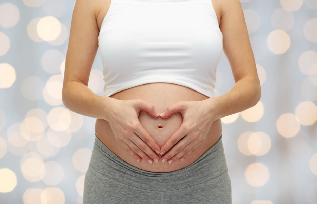 お腹に手をあてる女性