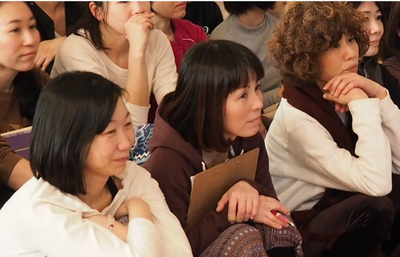 微笑む何人かの生徒さんがマーク先生の話を聞いている