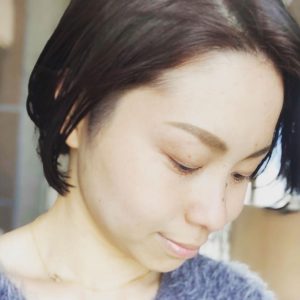 パープルのセーターを着た斜め下を向く女性