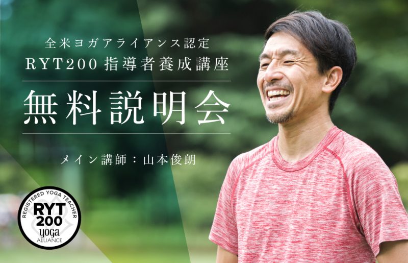 緑を背景に笑顔の山本俊朗