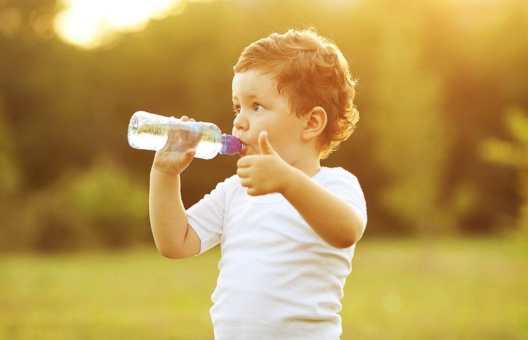 哺乳瓶に入った水を飲む子供