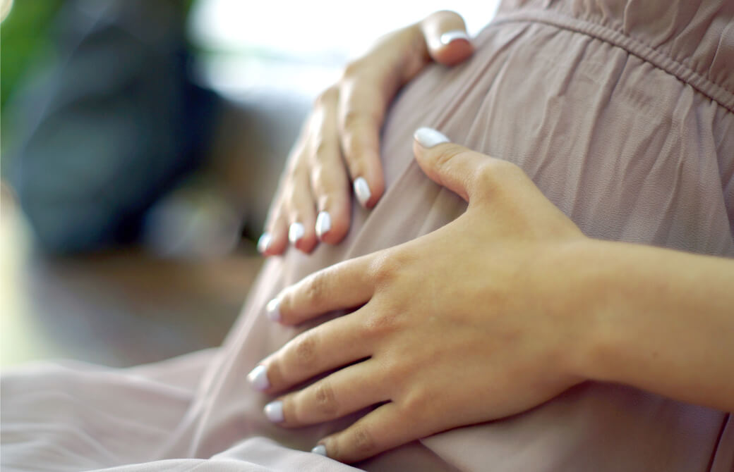 大きなお腹を抱える妊婦の手