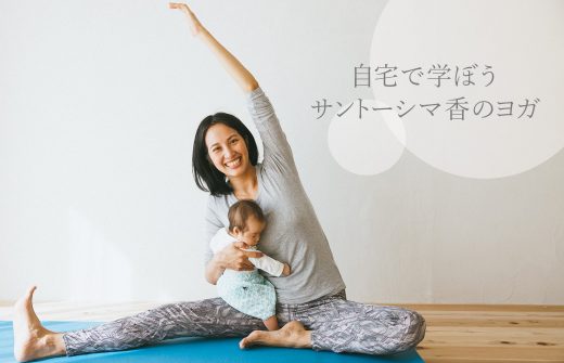 サントーシマ香先生がヨガマットの上で赤ちゃんを抱えてポーズを取っている