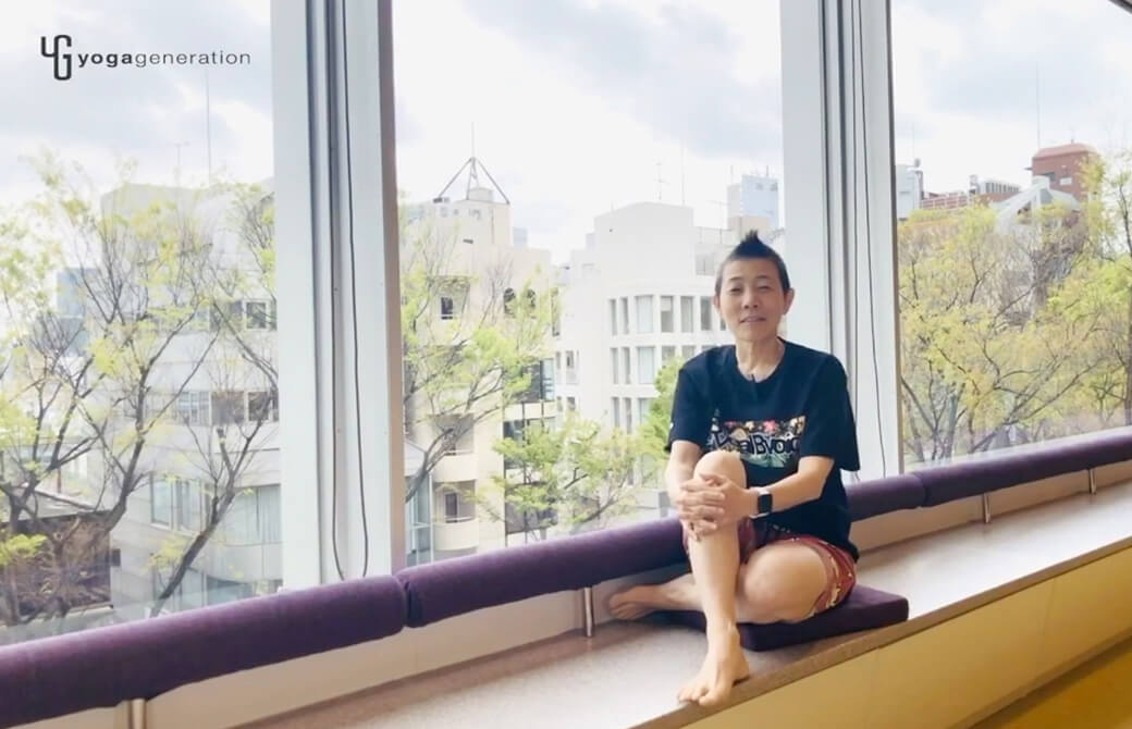 窓の前で座って語る高尾美穂先生