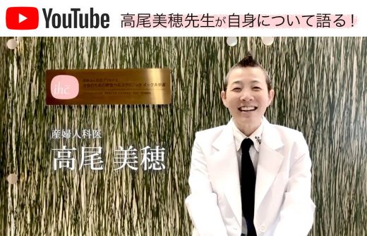 クリニックの看板の前で語る高尾美穂先生