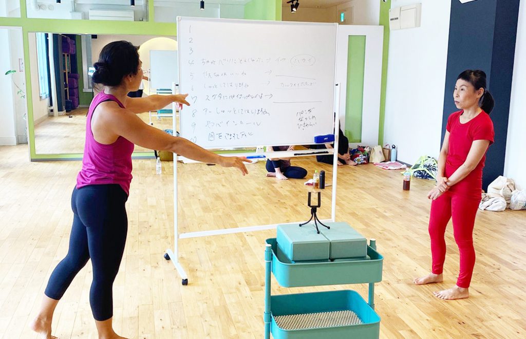 ホワイトボードを前に2人で打ち合わせ中
