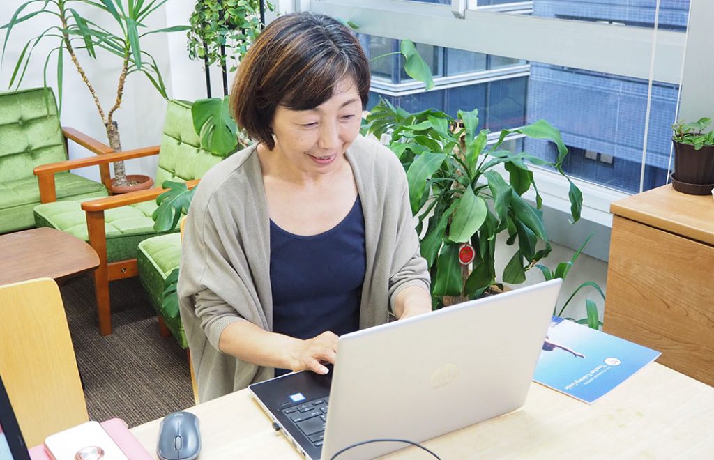 パソコンでの作業中。後ろは私が一生懸命育ててる緑たち
