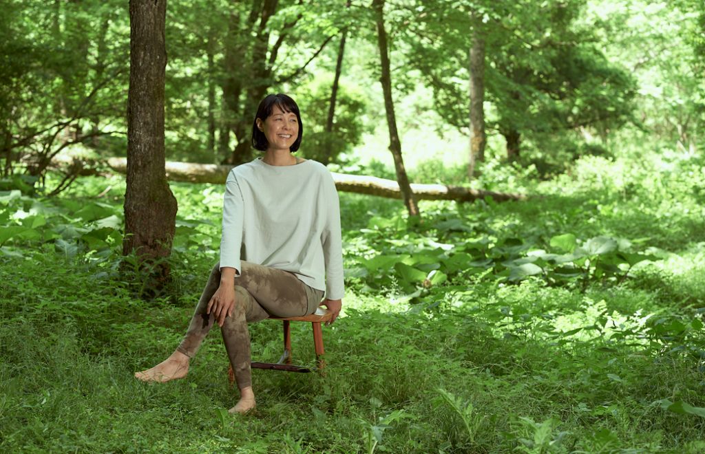 森の中で椅子に座ってポーズを取る山田いずみ先生
