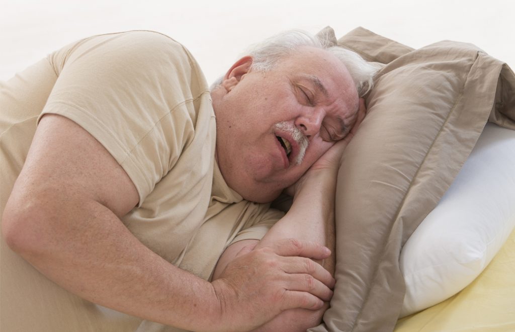 口を開けて寝ているひげを生やした男性