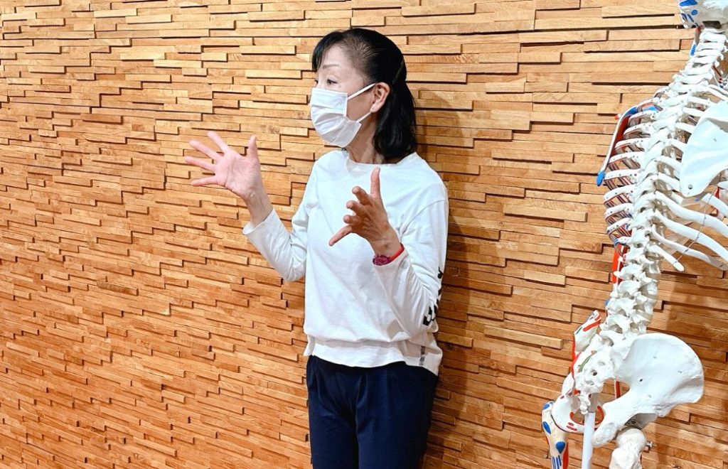 木の壁の前で講義中の柳生直子先生