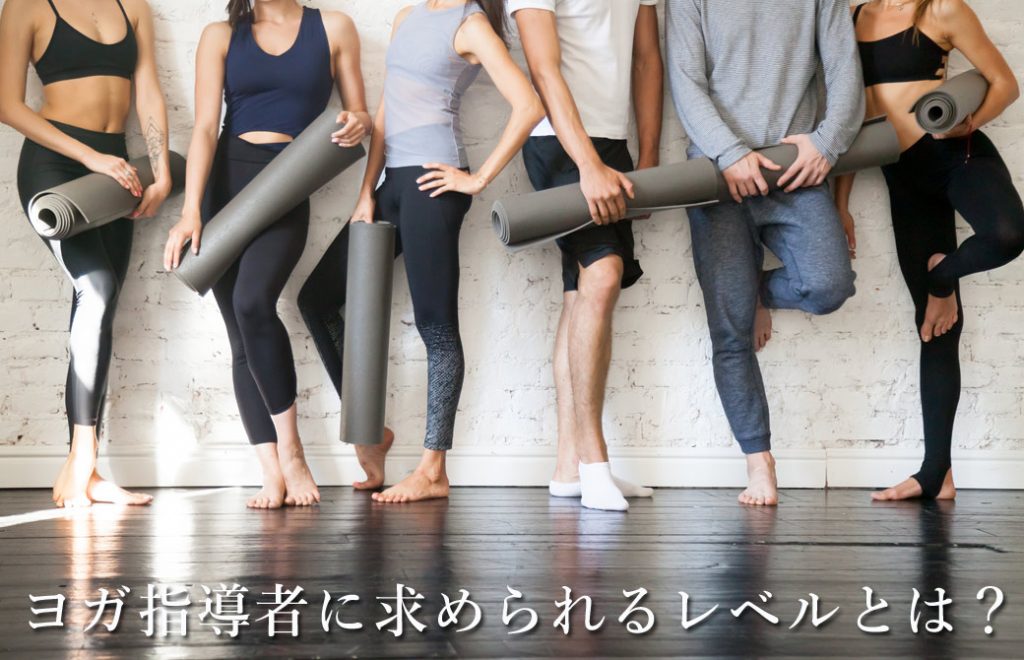 ヨガマットを持った人達が横並びに並んでいる