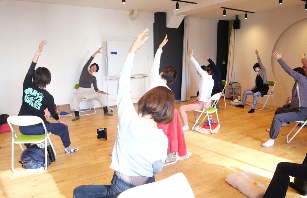 チェアヨガ講座風景　体側を伸ばしている