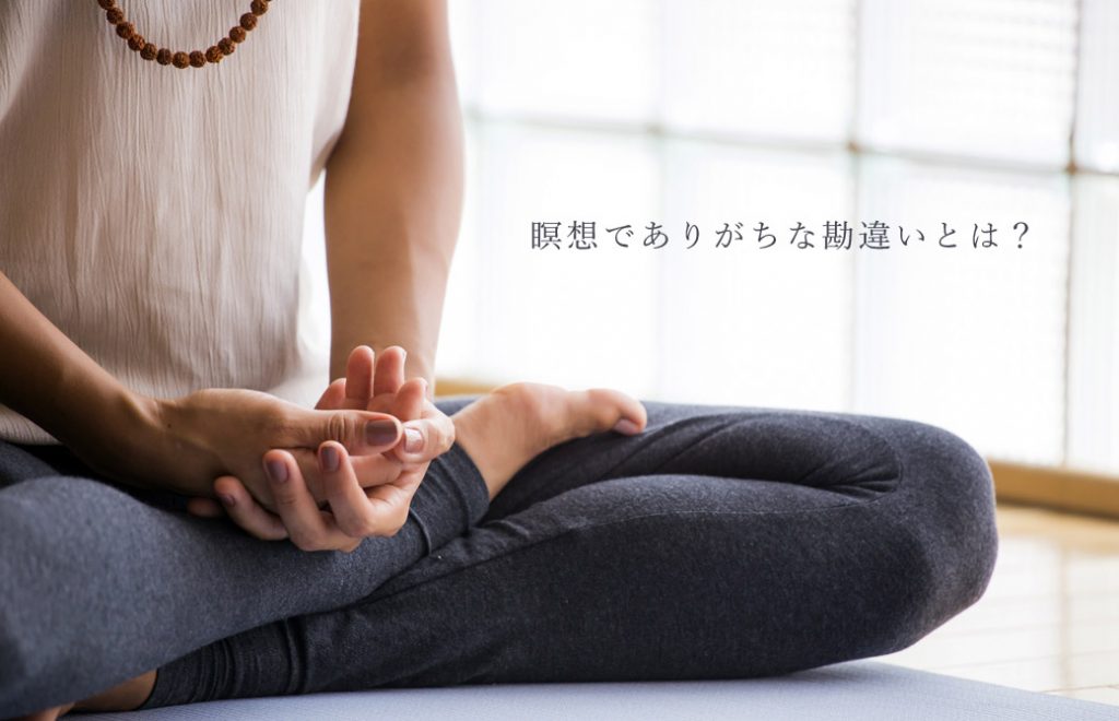 胡坐を組んで手を重ねている人の写真