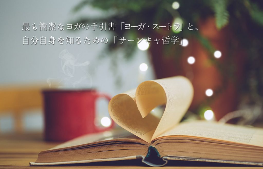 ページがハートに折られている本と赤いマグカップ