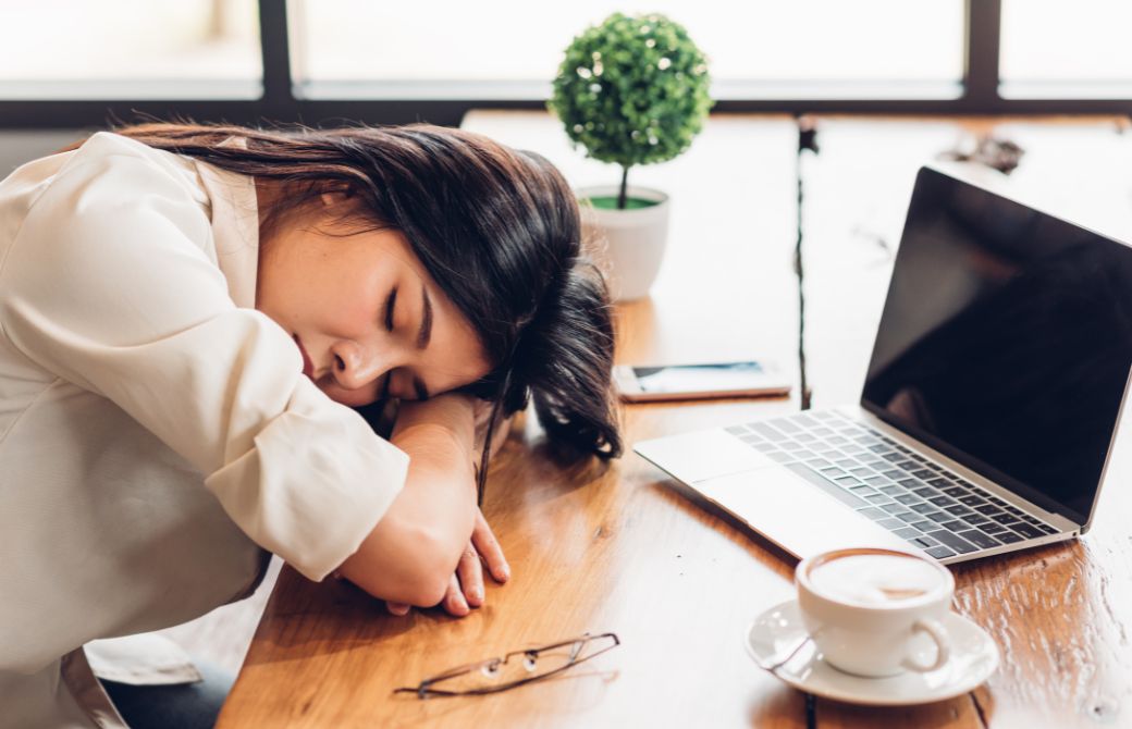 机で伏せ寝する女性